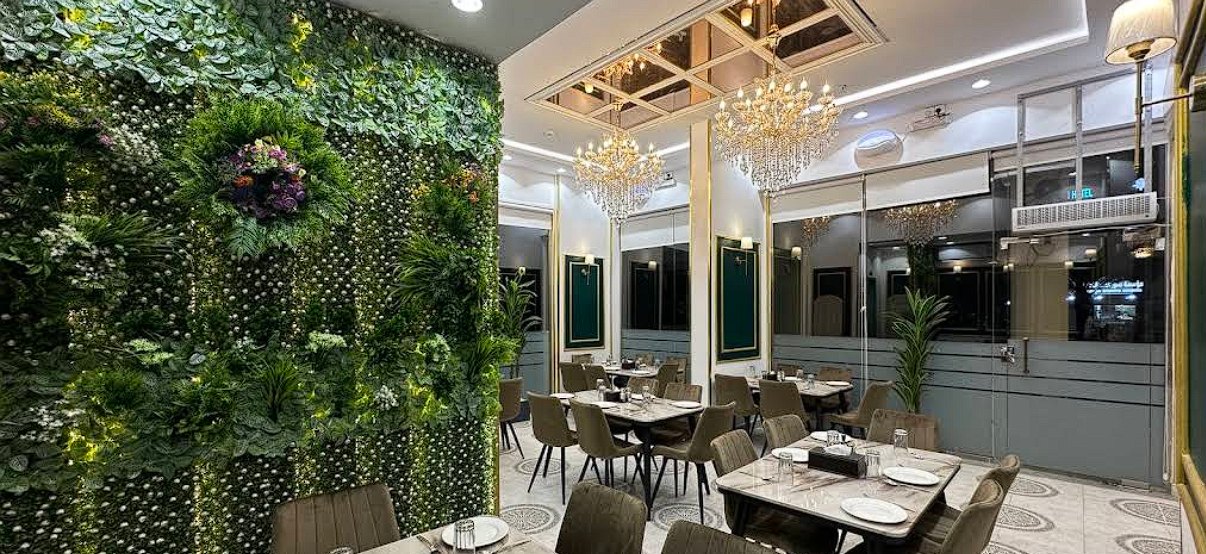 Elegant dining room at Alishaan Restaurant with living green wall and chandeliers